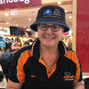 black bucket hat with a blue brim, standing in a retail store environment.